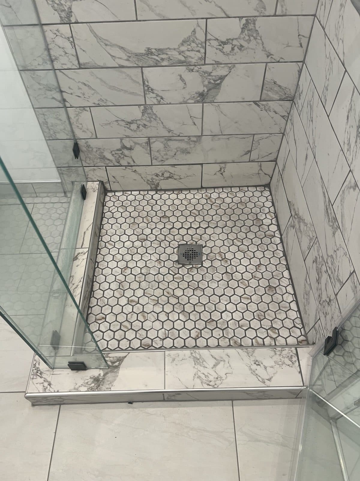 Hex tile shower floor and marble-look wall tile