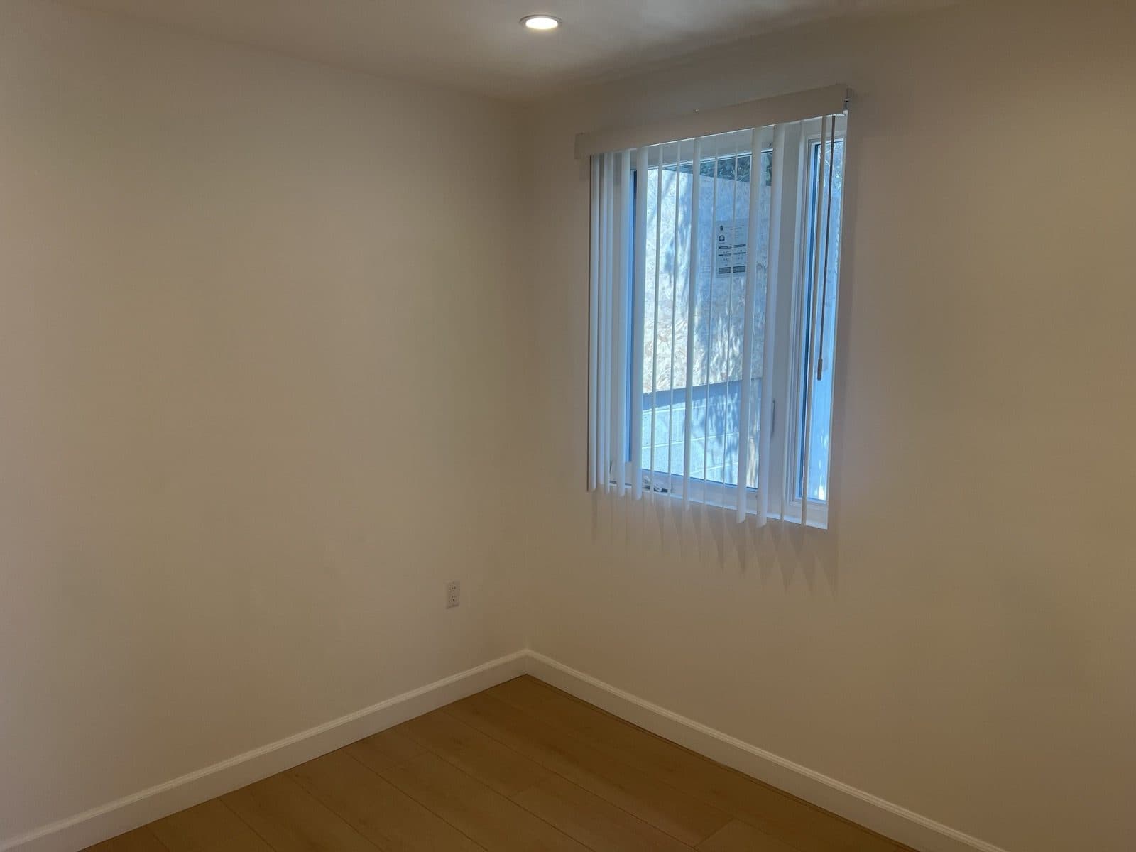 Finished bedroom with a new window and wood flooring