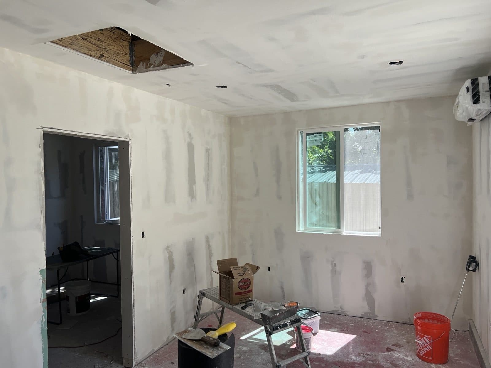 Drywall hung and taped, with the new window and mini split in place