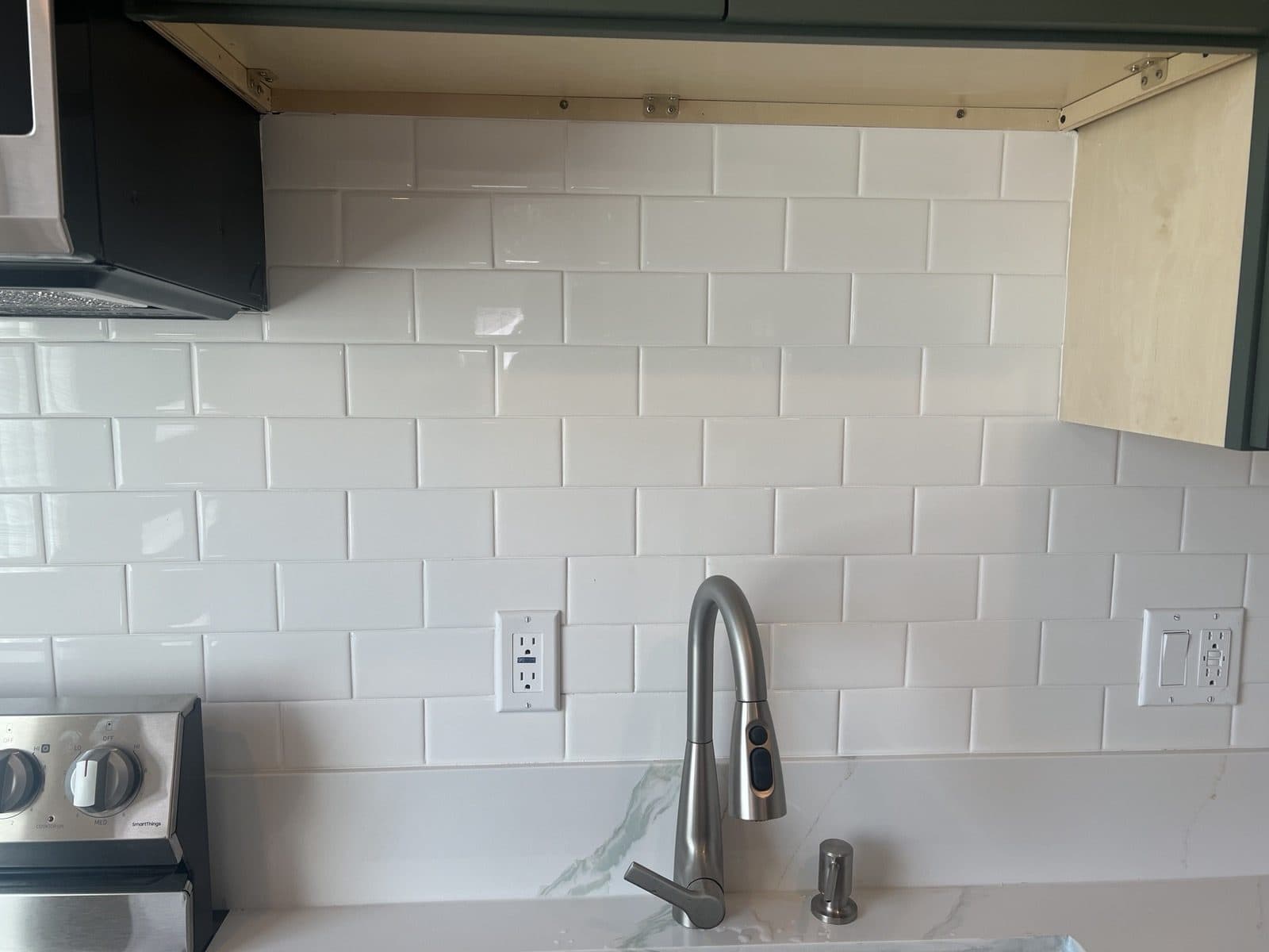 Subway tile backsplash and under-cabinet detail in the finished kitchen