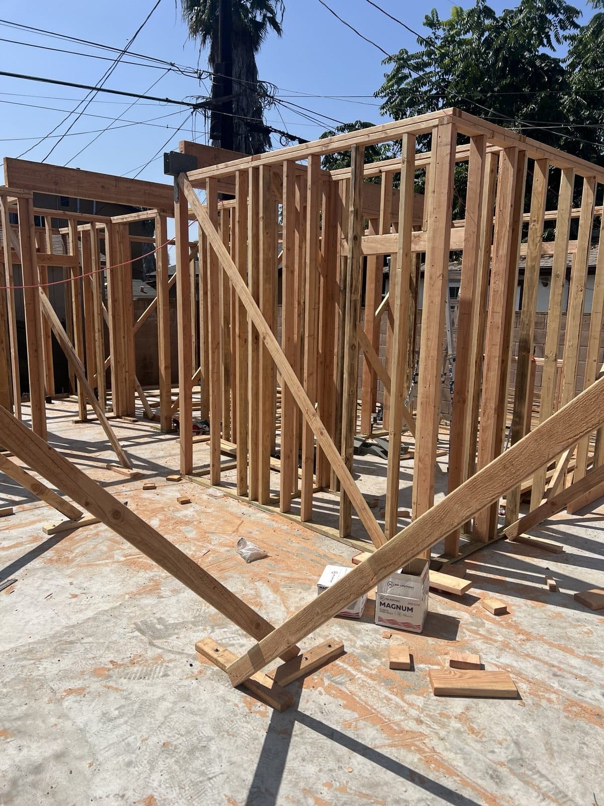 Framed corner with headers and bracing against a blue sky